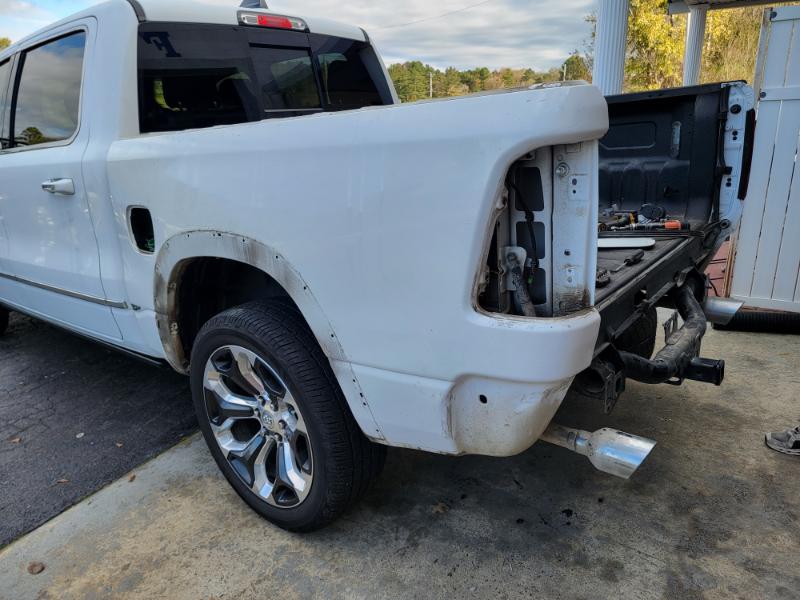 White pickup before repair with damaged rear body panel and removed tail light